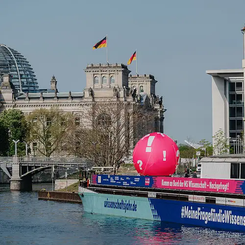 Die MS Wissenschaft im Wissenschaftsjahr 2022 an ihrer ersten Anlegestelle in Berlin Mitte. Im Hintergrund ist der Reichtstag zu sehen.