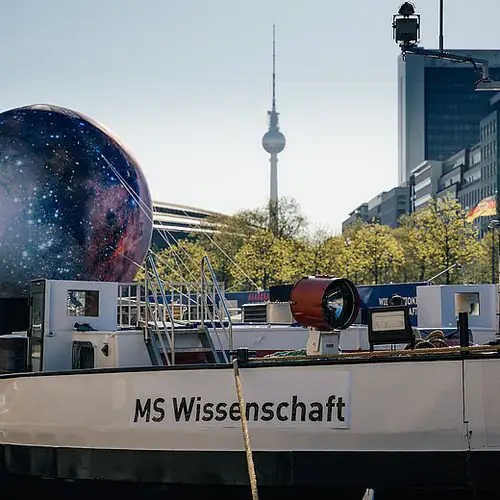 Die MS Wissenschaft im Wissenschaftsjahr 2023 - Unser Universum bei ihrem ersten Tourstopp am Schiffbauerdamm in Berlin-Mitte. Im Hintergrund ist der Fernsehturm zu sehen.