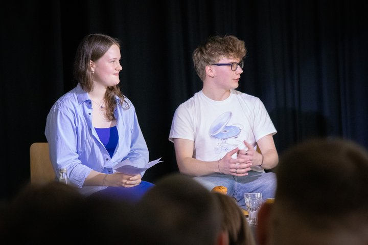 Zwei Schüler*innen moderieren auf Bühne
