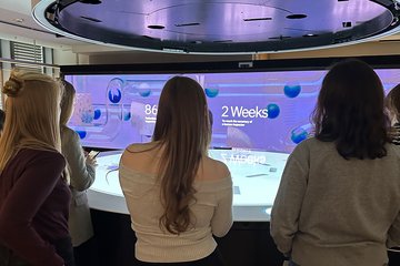 Personen vor einem blauen Display