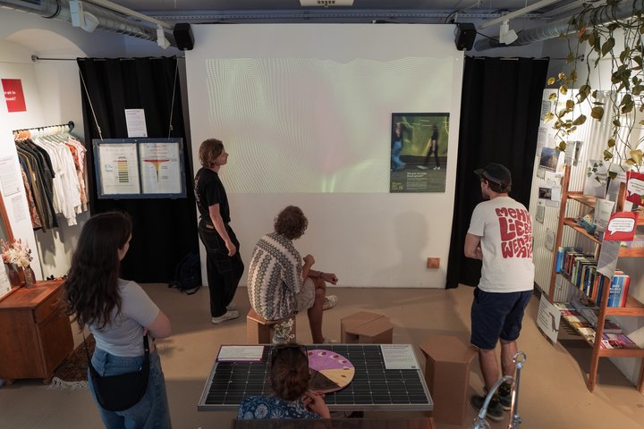 Fünf Personen in Ausstellungsraum vor Leinwand