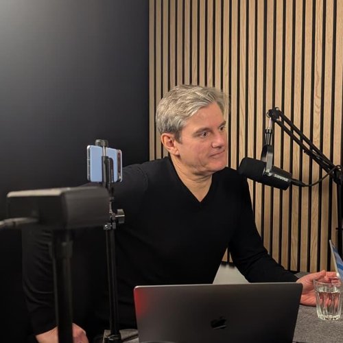 Thomas Ramge im Studio. Er trägt einen schwarzen Pullover. Vor ihm ein Mikrofon, auf der linken Seite eine Kamera.