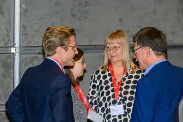 Mehrere Personen stehen zusammen und unterhalten sich.