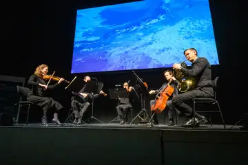 Musiker*innen spielen auf einer Bühne.