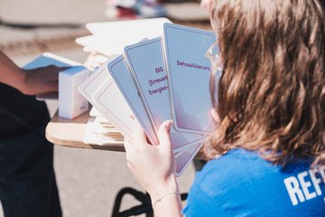 Blick über die Schulter einer Person, die Workshopkarten in der Hand hält.