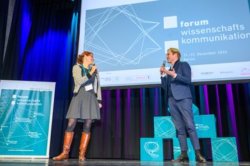 Zwei Personen im Gespräch auf Bühne