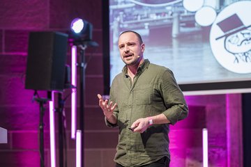 Science Slammer auf Bühne bei der Abendveranstaltung