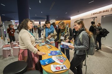 Personen unterhalten sich an Ausstellertisch