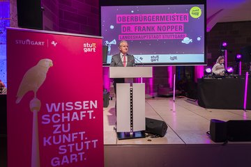 Person an Rednerpult auf Bühne