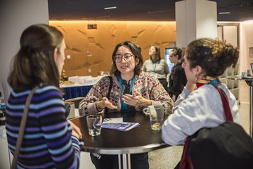 Personen am Stehtisch im Gespräch