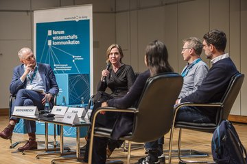 Personen auf Bühne bei Panel