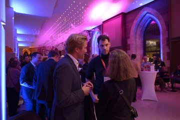 Person unterhalten sich bei Abendveranstaltung