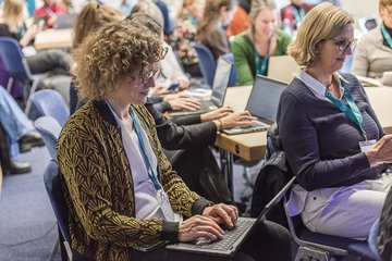 Personen arbeiten konzentriert am Laptop