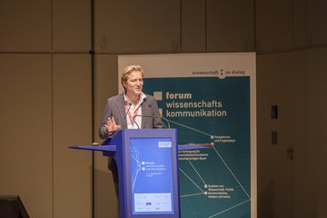 Abschlussworte des Geschäftsführers von Wissenschaft im Dialog (Person auf Bühne an Rednerpult)