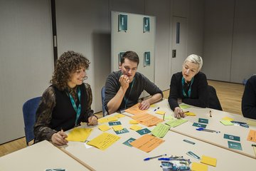 Personen an Tisch bei Gruppenarbeit