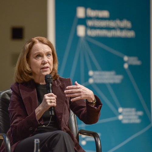 Eine Frau spricht in ein Mikrofon.