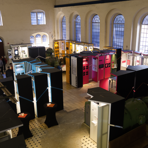 Aufsicht auf Ausstellung: Vier Themenbereiche mit zahlreichen Exponaten in einer Halle