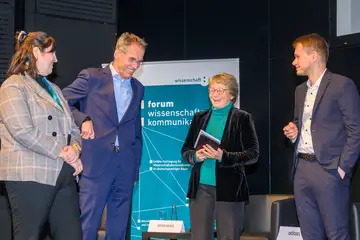 Mehrere Personen stehen auf der Bühne zusammen und reden.