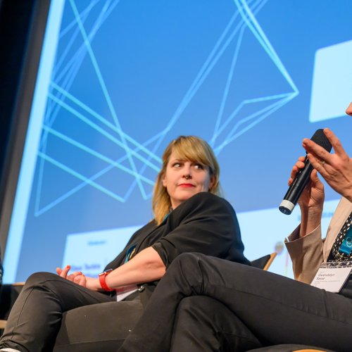 Drei Frauen sitzen nebeneinander und diskutieren.